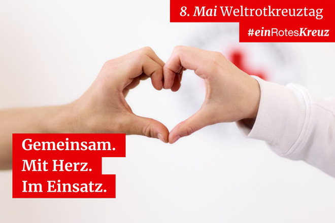  „Gemeinsam. Mit Herz. Im Einsatz.“  Zwei Hände formen ein Herz vor einem unscharfen Hintergrund mit einem Rotkreuz-Logo. Rechts oben steht „8. Mai Weltrotkreuztag“. Links unten steht weißer Text auf roten Balken: „Gemeinsam. Mit Herz. Im Einsatz. #einRotesKreuz.“